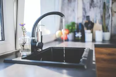 Water faucet in kitchen with water running