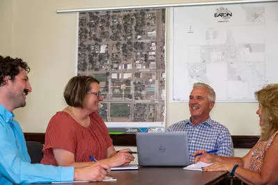 Town employees meet at a table in Town Hall